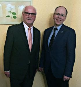 Bild: Im Vordergund steht Martin Beyer (r.) und Bürgermeister Hans Günther Oberlack vor einer gelben Zimmerwand. (Foto: CDU Glienicke)